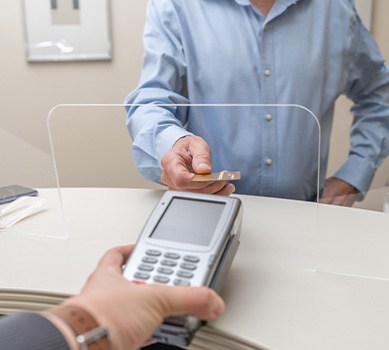 A man using a credit card to pay for dental implants